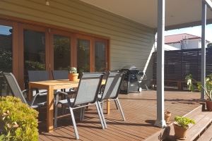 The rear deck of our Cooks Hill Cottage provides an outdoor dining setting, additional seating and BBQ.